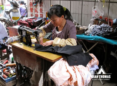 Lady making clothing repairs at the market