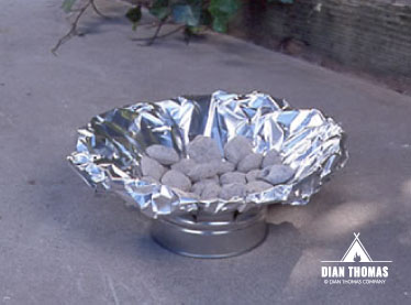 Line the tin can with heavy duty foil before adding charcoal